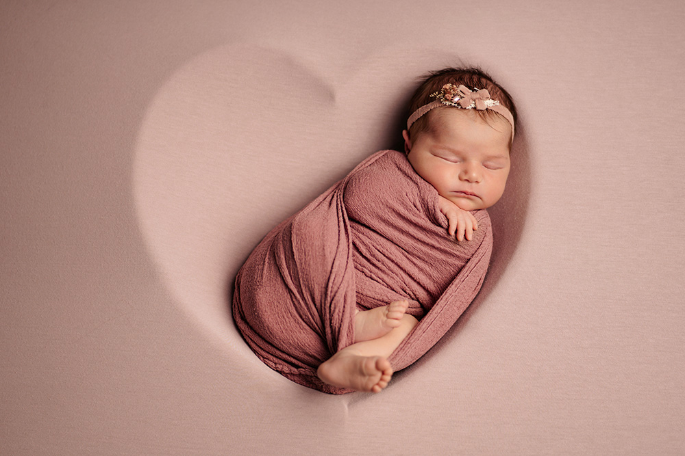 Baby mit Blume im Haar – stilvolles Newbornshooting