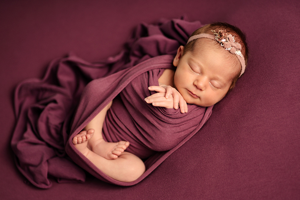 Neugeborenes Baby im Pucktuch – Babyshooting im Studio Herford
